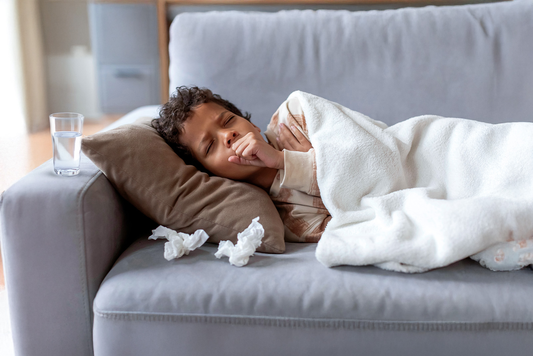 Sick child in bed coughing, needing Ayurvedic immunity support.